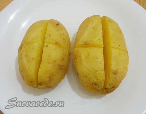 Готову картоплю надрізати хрест на хрест, але не дорізати до кінця, щоб картопля зберіг свою форму